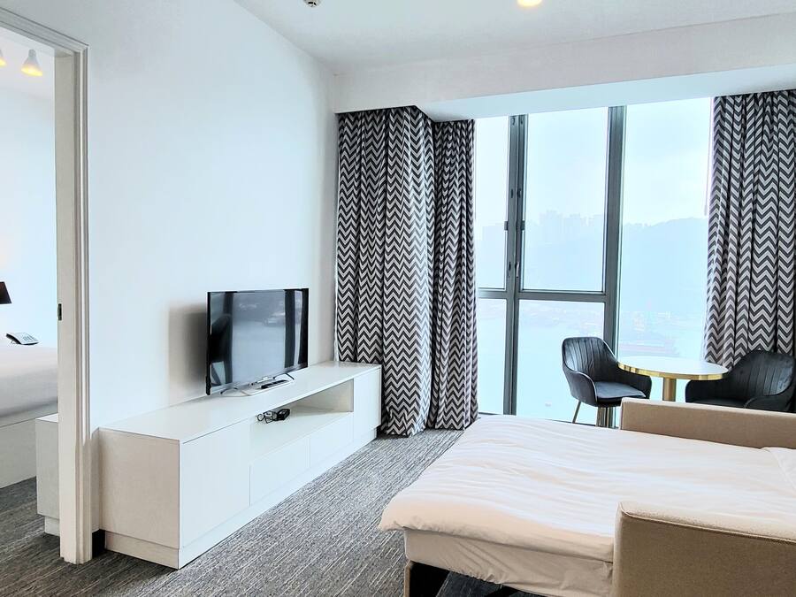 Une chambre d’hôtel moderne équipée d’un lit, d’une télévision, d’un bureau et d’une chaise.