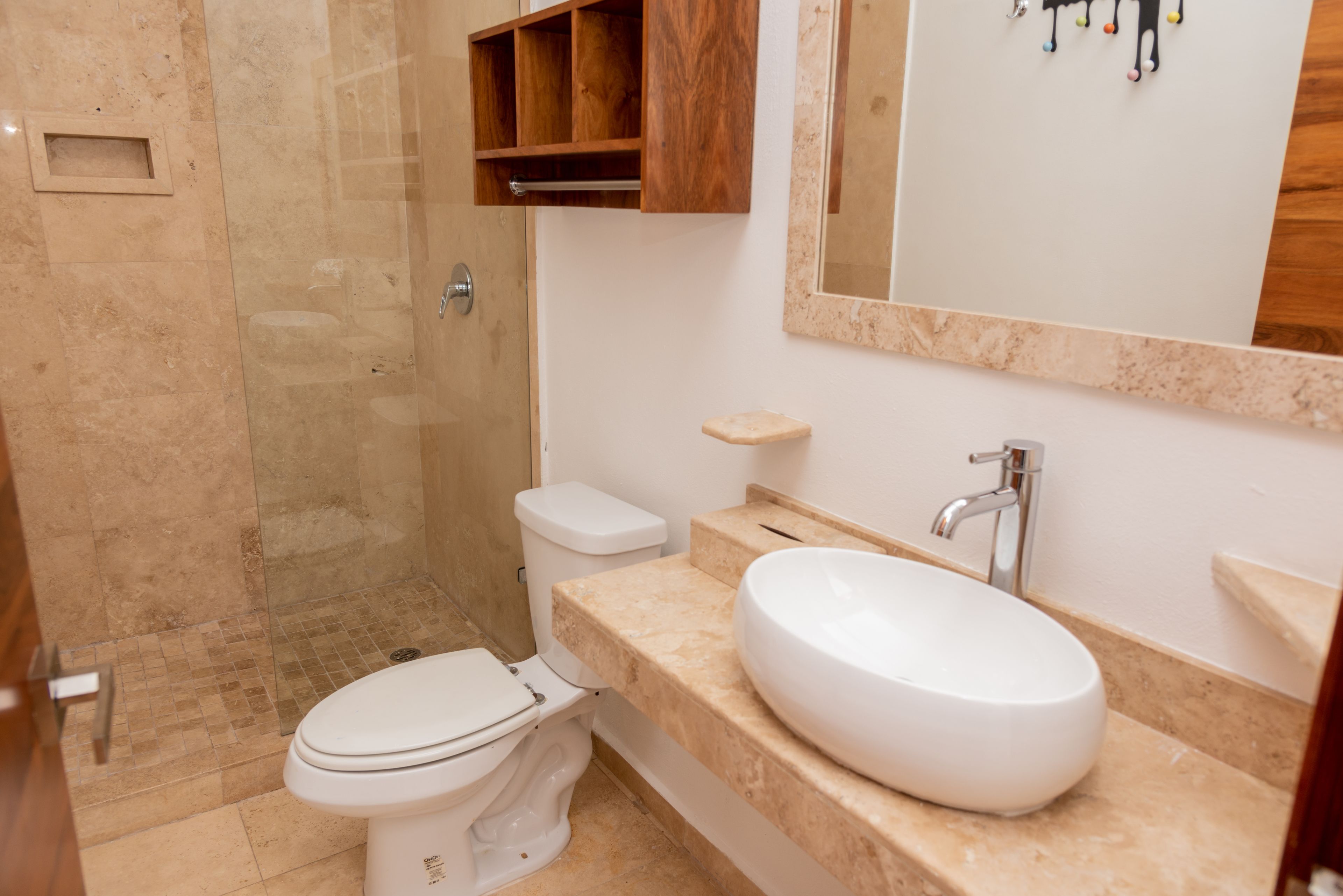 Une salle de bain comprenant des toilettes, un lavabo et un espace douche.