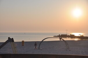 Eine Strandansicht mit Sonnenuntergang, einer Leiter und einer Metallkonstruktion.