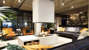 Una sala de estar moderna con chimenea, sofás de cuero y una mesa de centro.