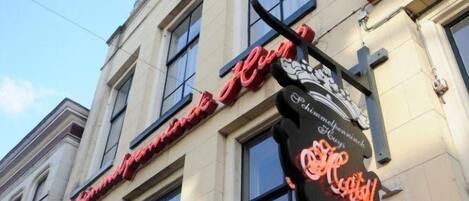 A hotel with a large, ornate sign featuring the name "Hotel Imperial" in red neon lights.