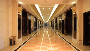 A long, well-lit hallway with marble flooring and large doors on either side. - Country Garden Phoenix Hotel Tongliao (Tongliao)