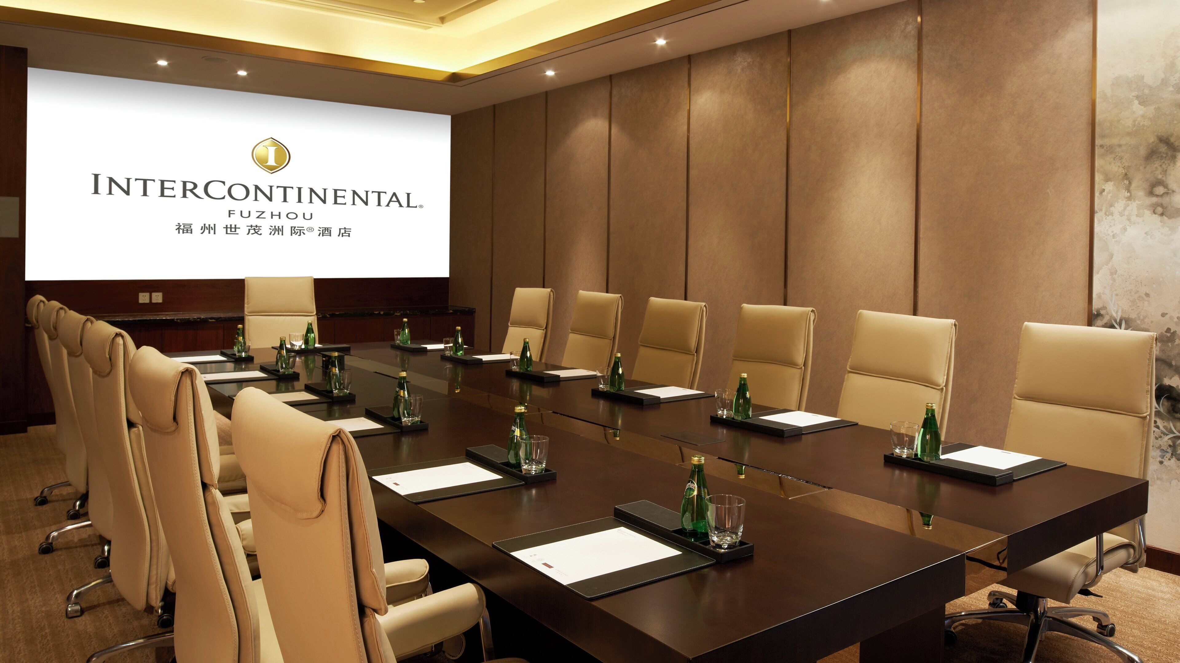 A conference room with a long table, chairs, and a projection screen displaying 'INTERCONTINENTAL FUZHOU'.