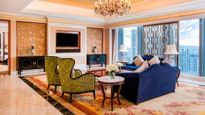 A spacious living room with a large chandelier, a blue sofa, patterned chairs, a TV, and a view of the city. - InterContinental Fuzhou by IHG (Fuzhou)