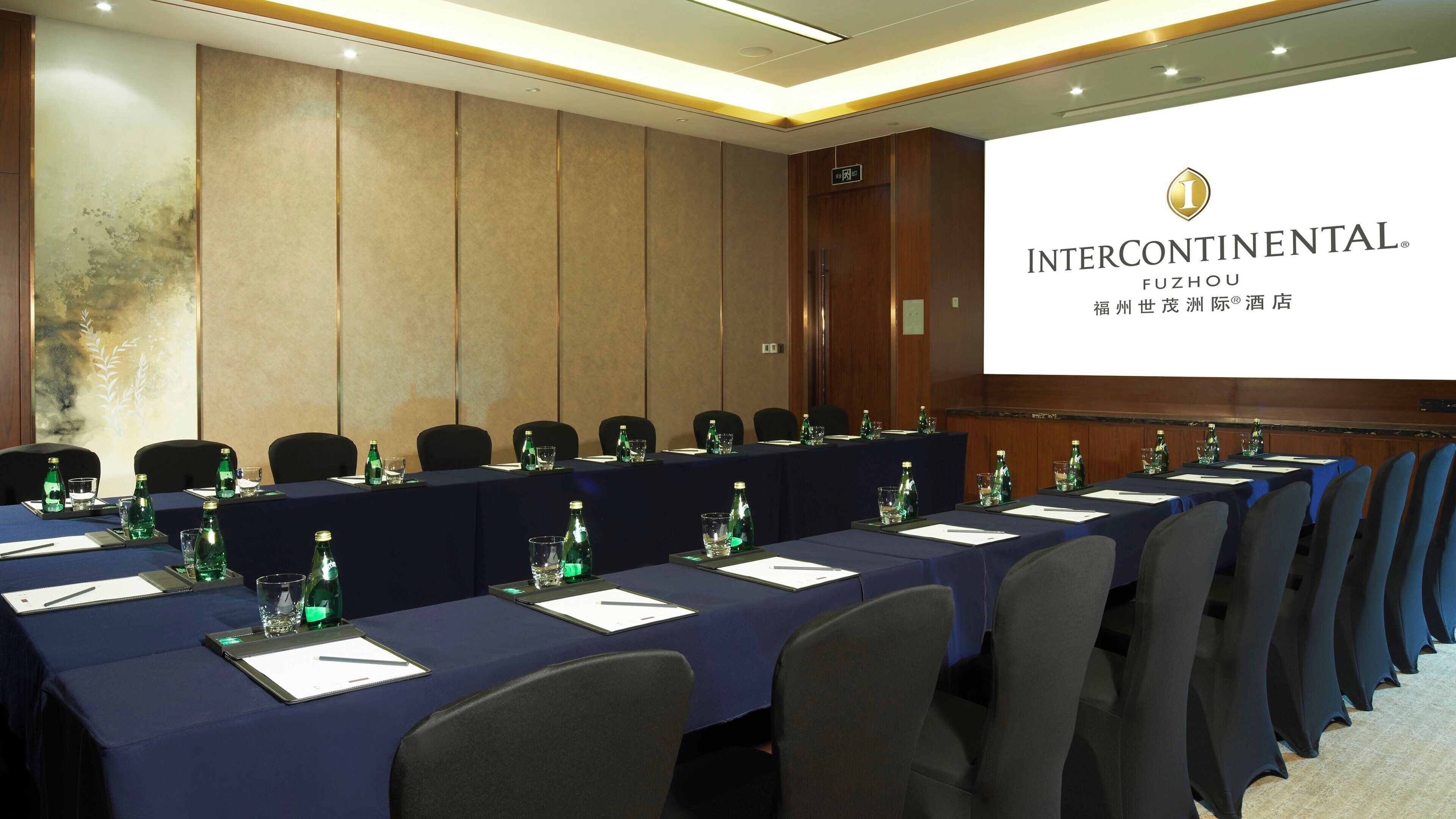 A conference room with a long table, chairs, and a projection screen displaying the Intercontinental Fuzhou logo.