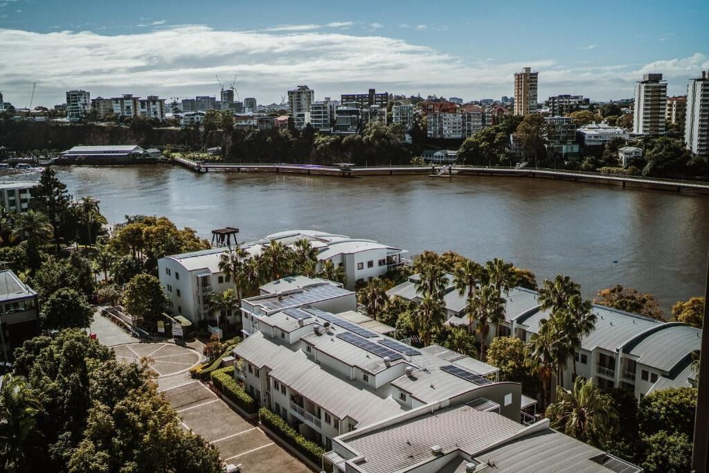 Un paysage urbain côtier avec des bâtiments modernes, un port de plaisance et une rivière.