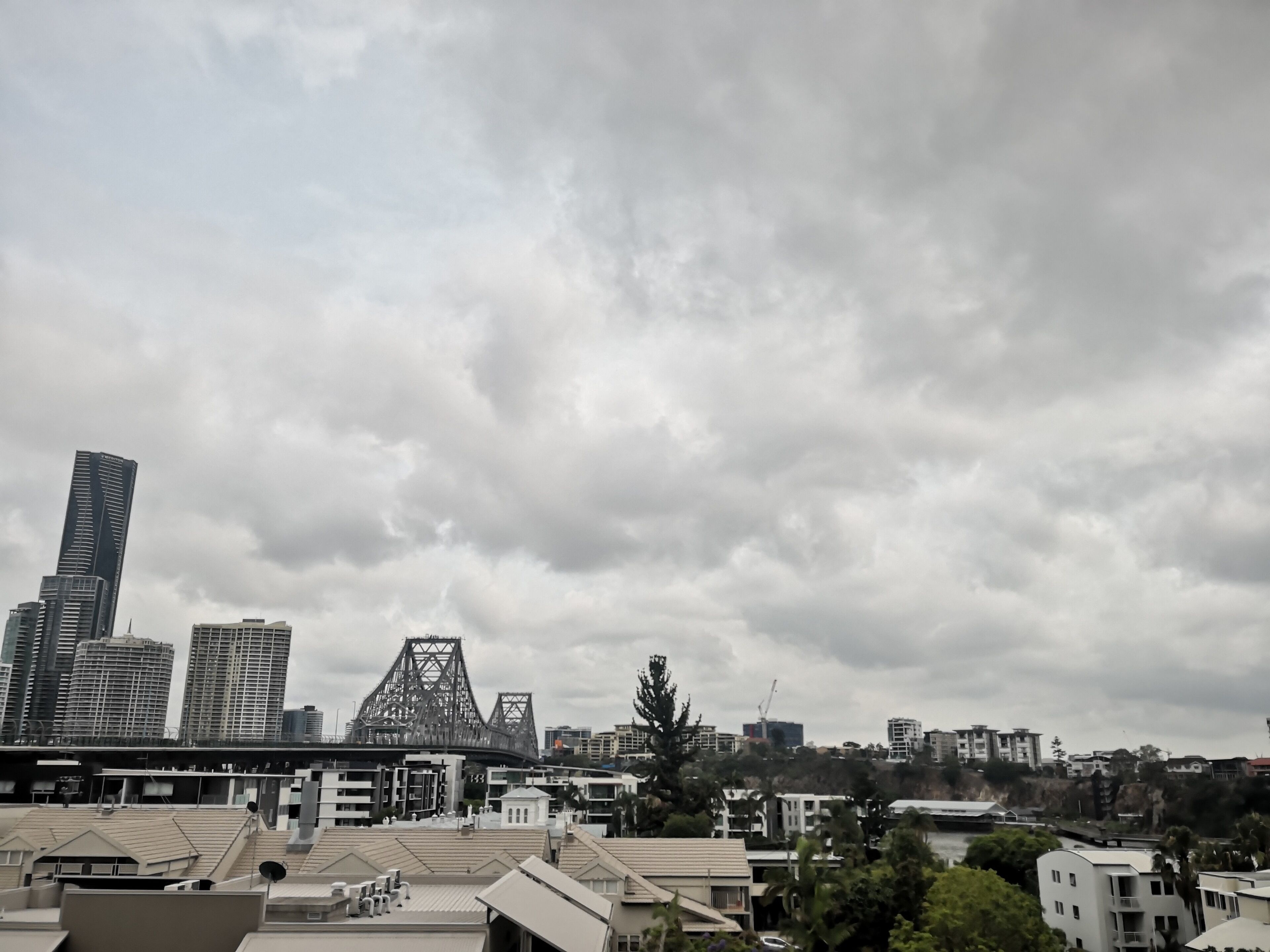 Un paisaje urbano con edificios modernos, un puente destacado y una combinación de construcciones residenciales y comerciales.