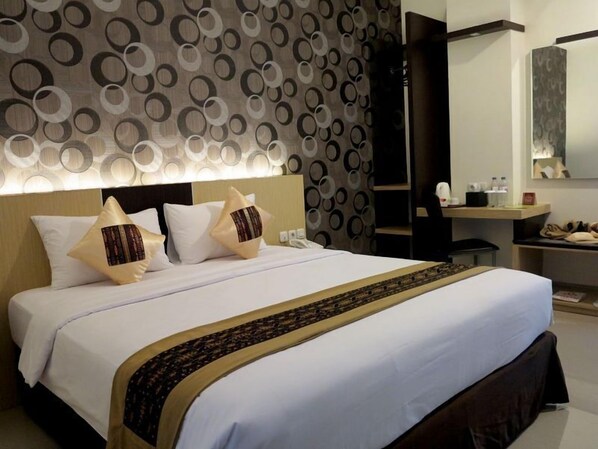 Una habitación de hotel moderna con una cama grande, un escritorio y un espejo.