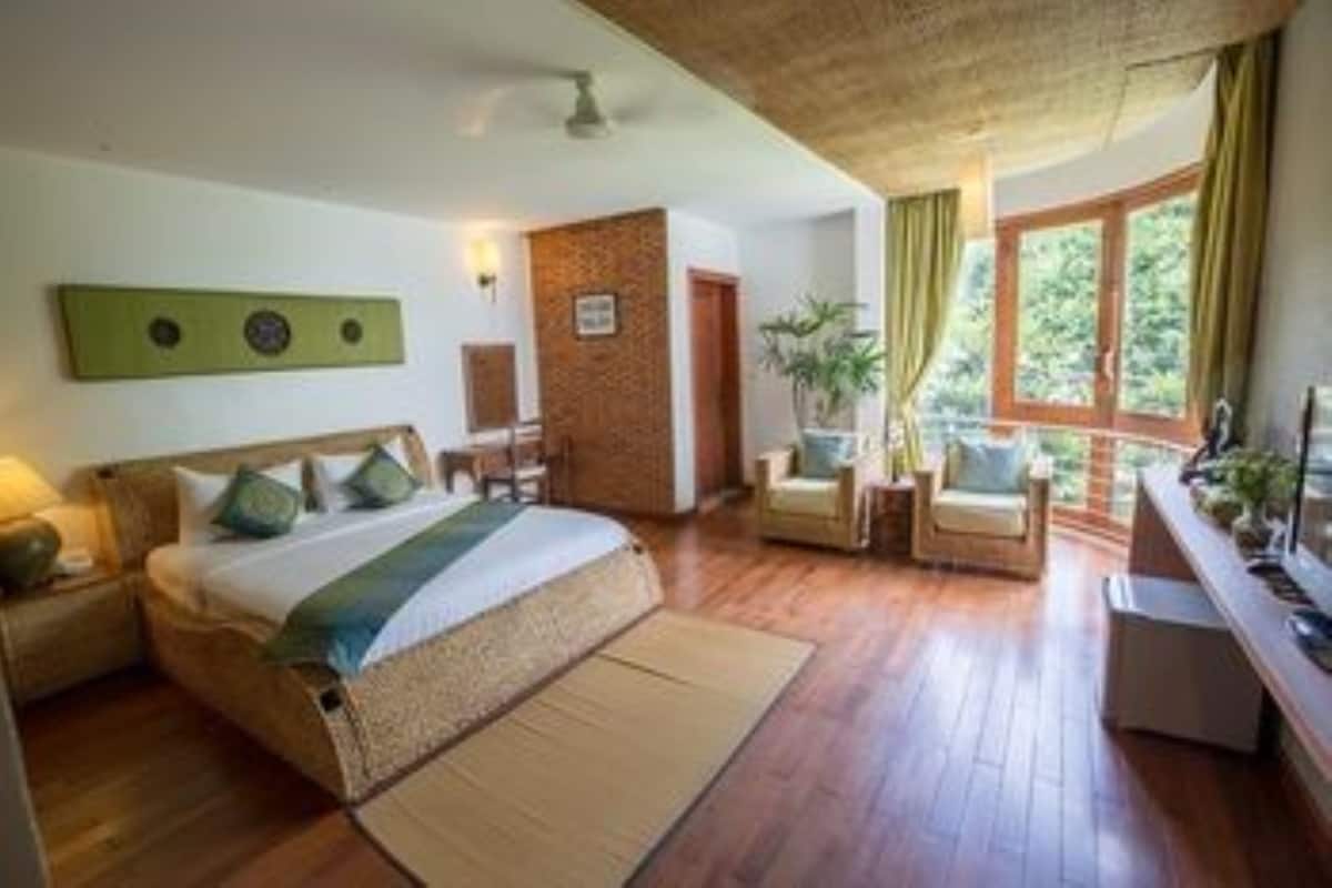 A room with a bed, a chair, a small table, and a window.