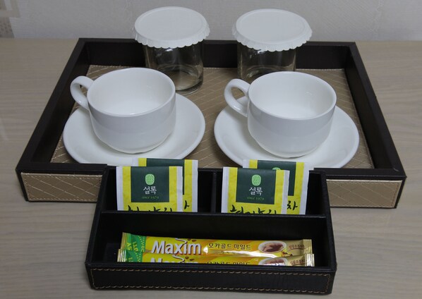 A tray with four white cups and saucers, two tea packets, and a box labeled "Maxim". - Hotel Daewoo Inn (Seoul)