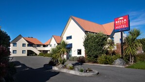 A Bella Vista Motel with a modern design, featuring a parking lot and landscaped areas with various plants. - Bella Vista Motel Kaikoura (Kaikoura)