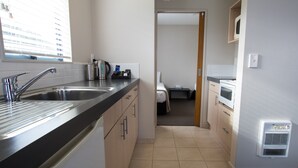 A compact kitchen with a stainless steel sink, a coffee machine, and a microwave. - Bella Vista Motel Kaikoura (Kaikoura)
