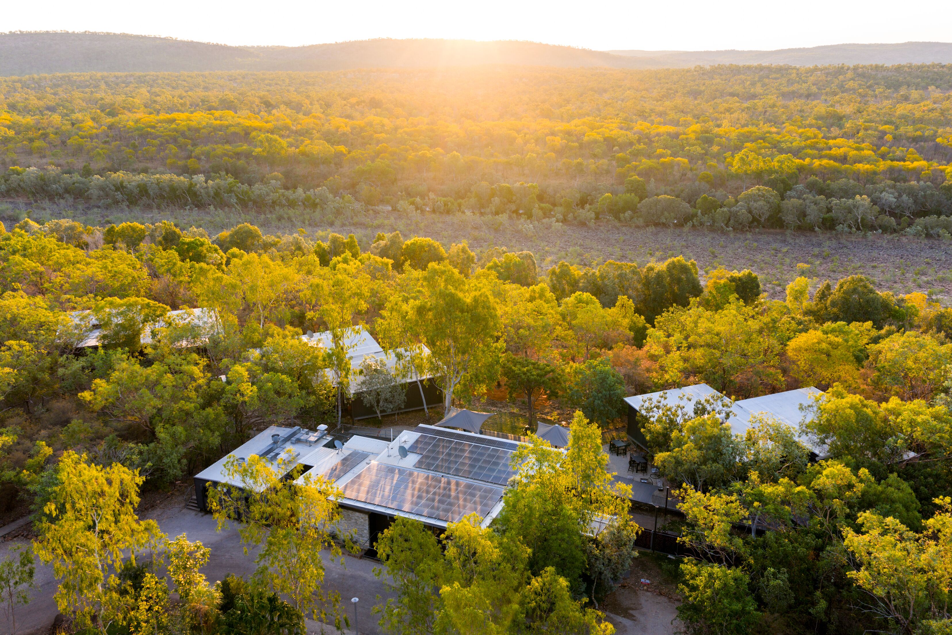 A solar-powered building surrounded by dense forest, with a clear view of the surrounding landscape.