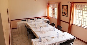 A conference room with long tables, chairs, water bottles, and nameplates. - Annie's Lodge Blantyre (Blantyre)