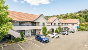 Un hôtel moderne à l’architecture contemporaine, composé de deux étages, doté d’un parking couvert et situé au pied d’une colline.