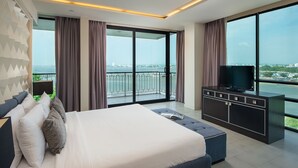 Une chambre moderne avec un grand lit, une télévision et un balcon offrant une vue sur la ville.