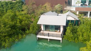 Une péniche dotée d’un balcon, entourée d’eau et de verdure.