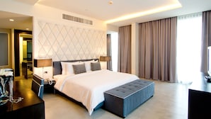 Une chambre d’hôtel moderne, dotée d’un grand lit, d’un bureau et d’une télévision.