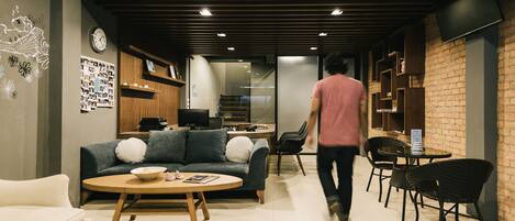 Een modern interieur met een bank, salontafel en eethoek.