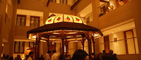 A large, ornate gazebo with stained glass windows in a hotel lobby.