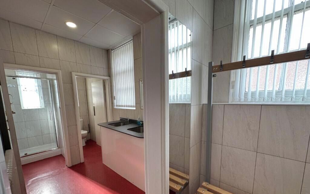 A bathroom with a shower, toilet, and sink.