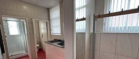 A bathroom with a shower, toilet, and sink.