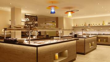 Uma área de buffet moderna com várias estações de serviço, uma apresentação central e uma variedade de alimentos.