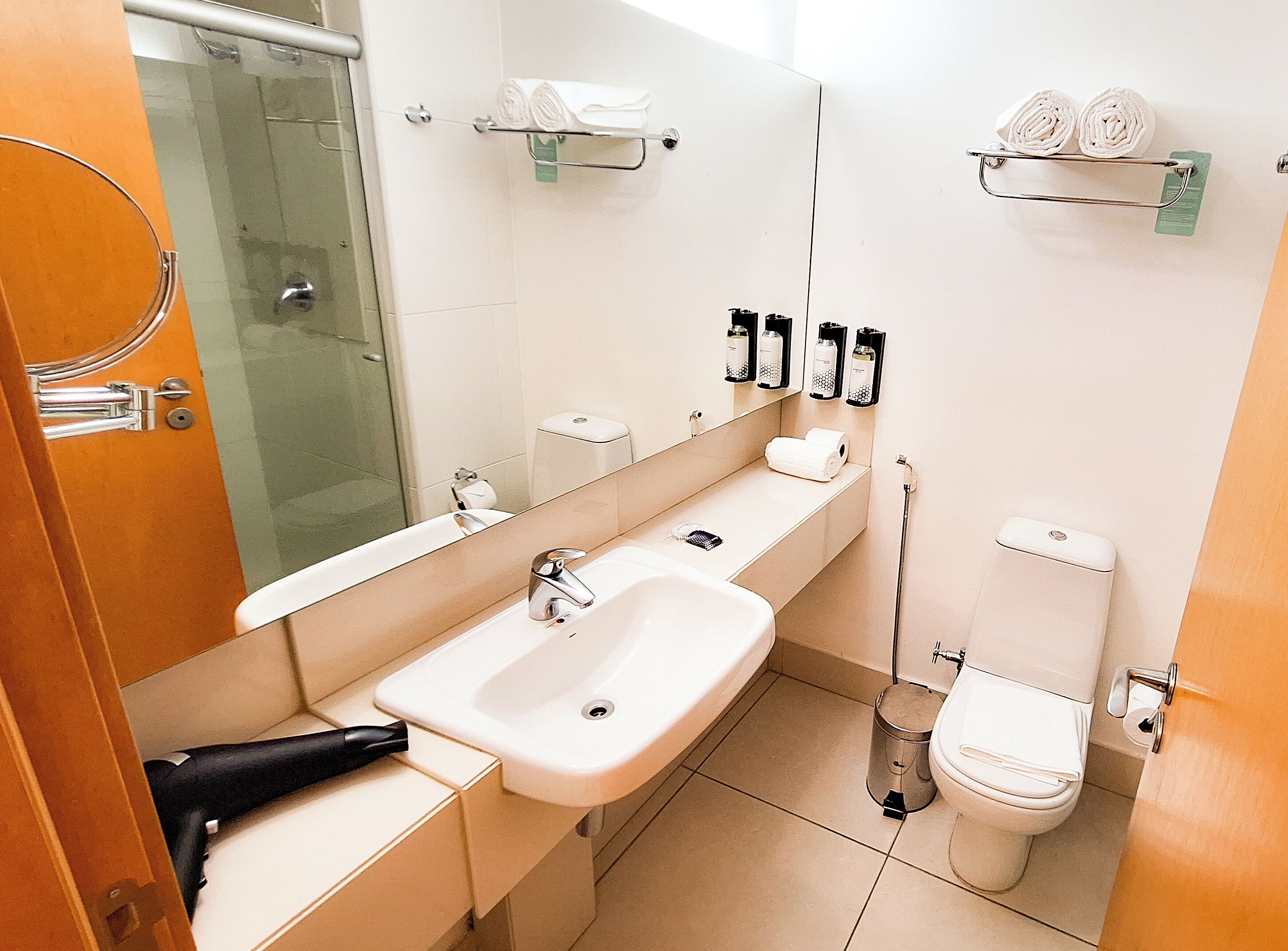 Ein modernes Badezimmer mit Waschbecken, Spiegel, Toilette und Dusche.