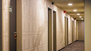 A hotel hallway with doors numbered 125 and 1072, carpeted floors, and a fire alarm on the ceiling. - McDreams Hotel Wuppertal City (Wuppertal)