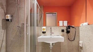 A bathroom with a shower, sink, and toilet. - McDreams Hotel Wuppertal City (Wuppertal)