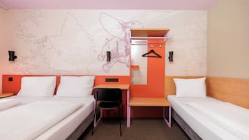 A hotel room with two beds, a desk, a chair, and a map on the wall.