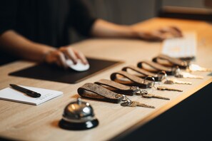 Un bureau avec un bloc-notes, un stylo, des clés et une clochette.
