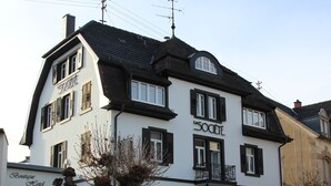 Een gebouw met twee verdiepingen, met een bord met daarop 'HOTEL' en 'la SOCIETE' op de gevel.