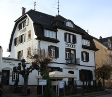 Un edificio de dos pisos con un letrero que dice "HOTEL" y "la SOCIETE" en la fachada.