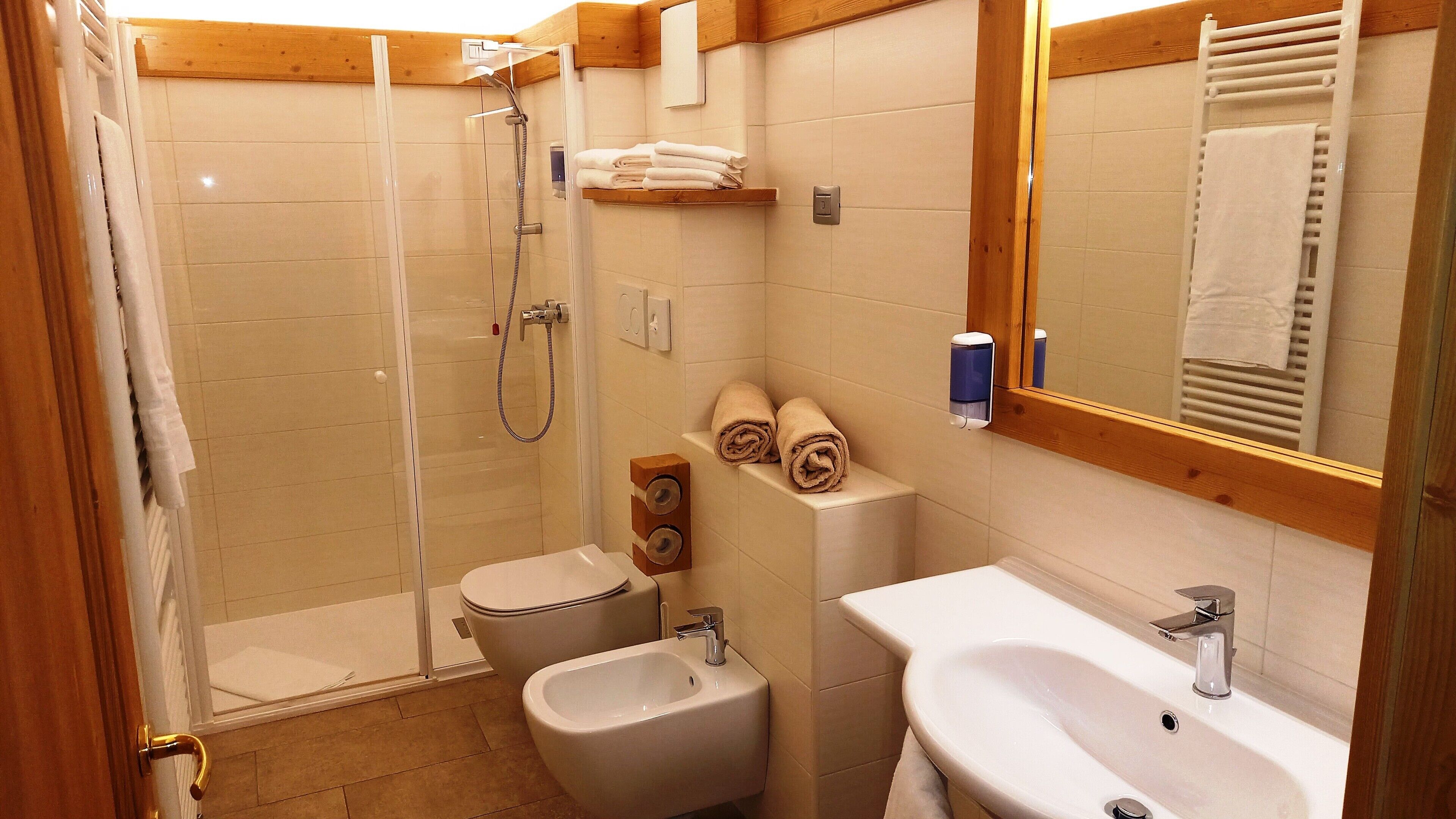 Une salle de bain équipée d’une douche, de toilettes, d’un bidet et d’un lavabo.