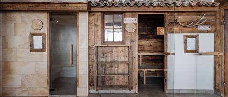 Un interior rústico con paredes de madera, piso de baldosas y una puerta de madera con panel de vidrio.