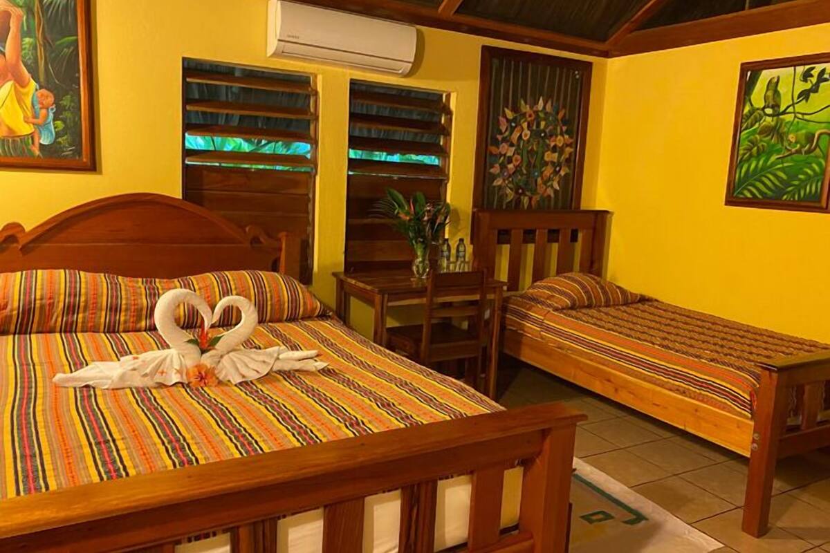 A room with two wooden beds, a small table, and chairs.