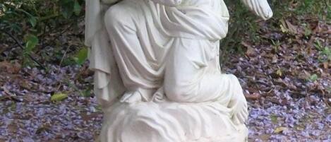 A statue of an angel kneeling and embracing a child.