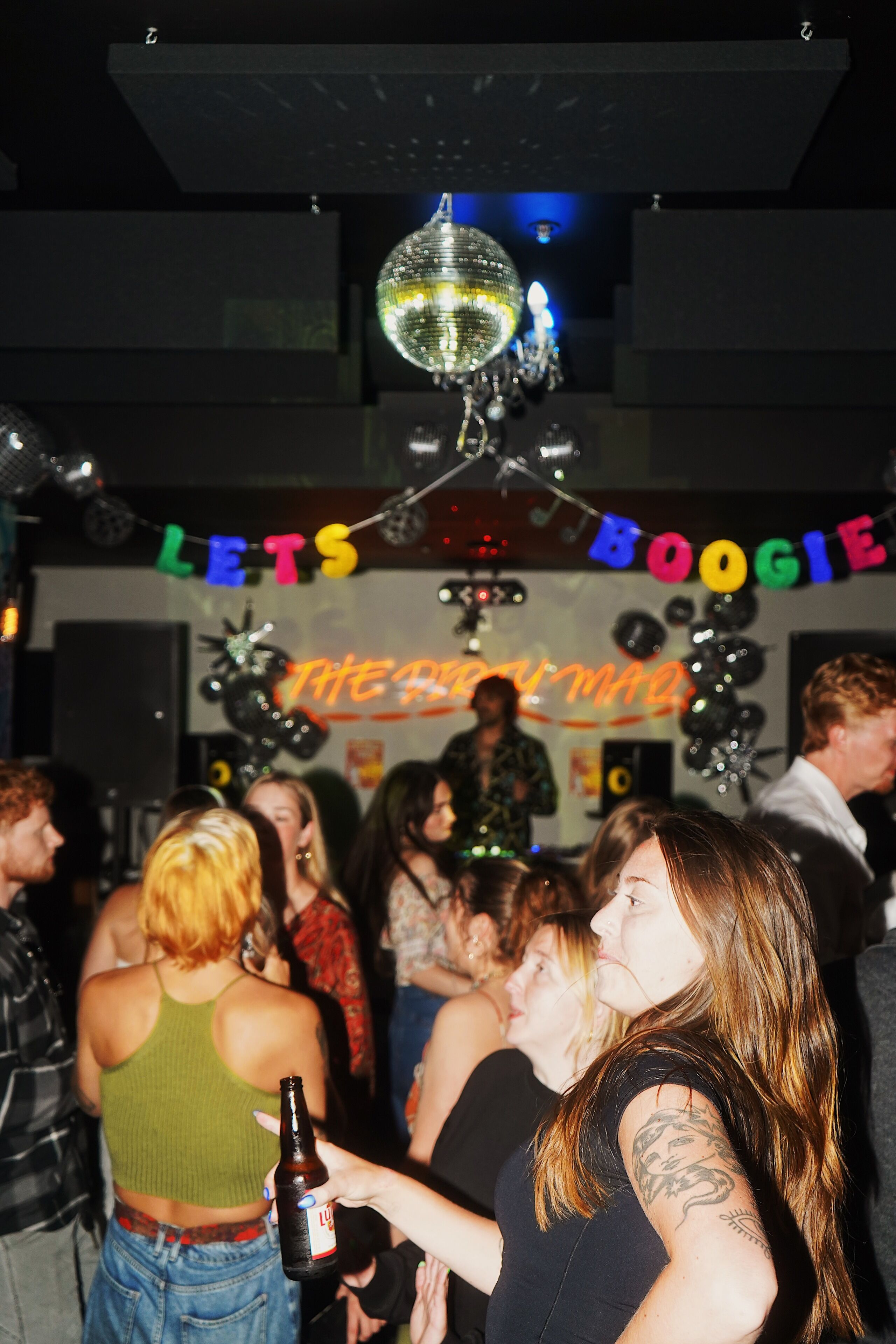 A crowded indoor space with a disco ball hanging from the ceiling.
