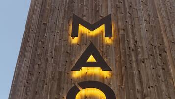 A wooden wall with illuminated letters spelling 'MAQ'.