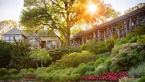 A house with a stone wall and a garden with various plants and flowers. - Gurney's Montauk Resort & Seawater Spa (Montauk)