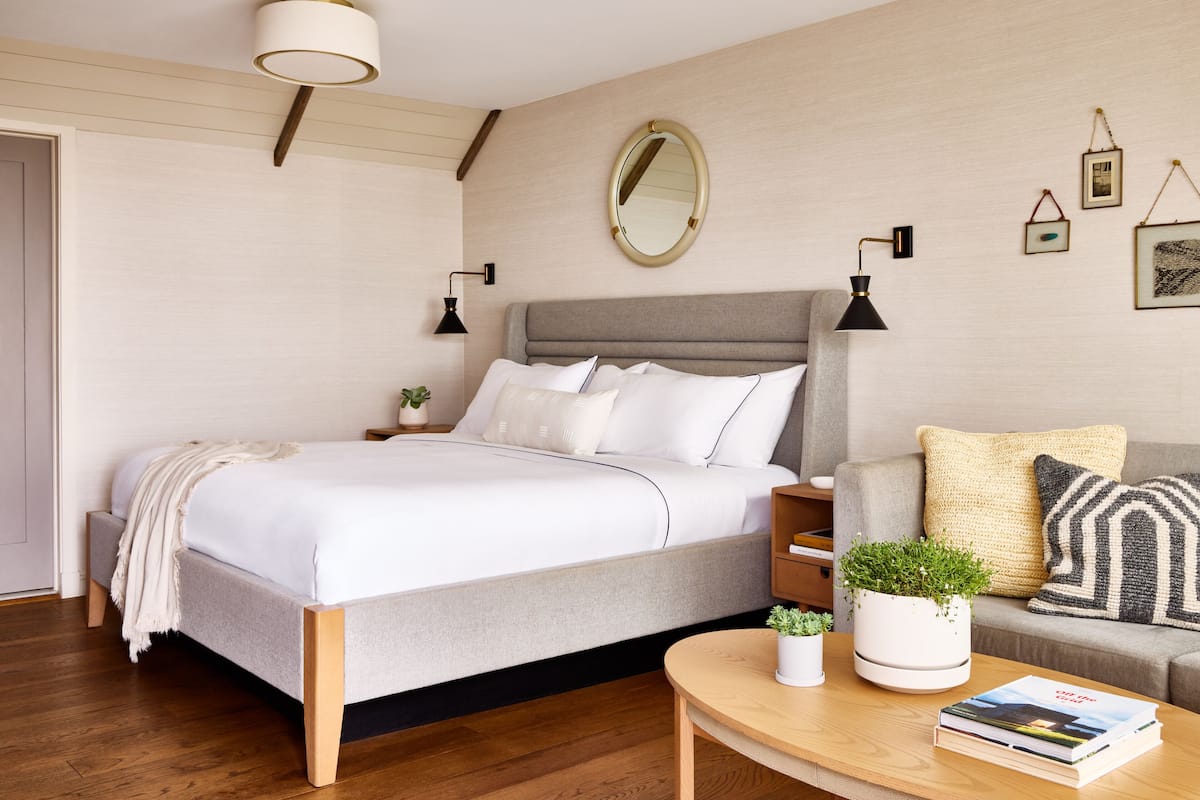 A modern bedroom with a bed, bedside tables, a sofa, and a coffee table.