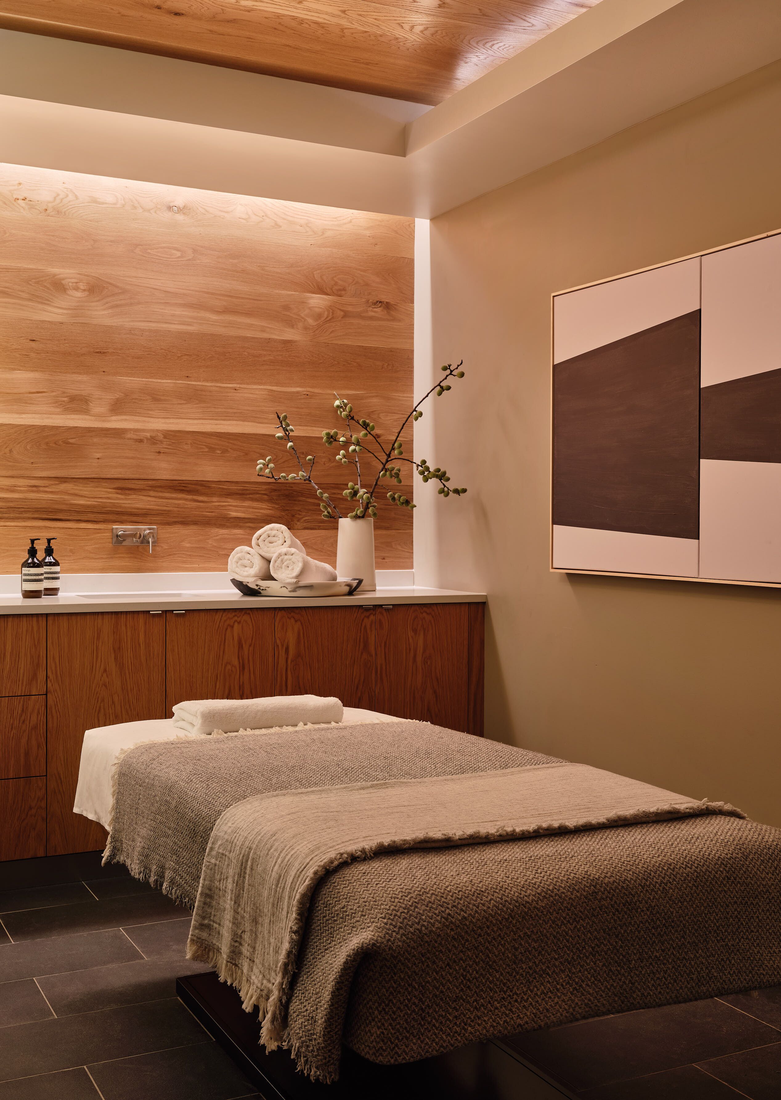 Un baño moderno con muebles de madera, un espejo grande, un lavabo y un perchero para toallas.