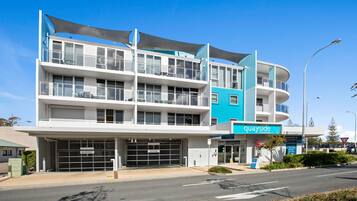 A multi-story hotel with a blue and white facade, ground-level parking, and a visible sign for 'quayside'.