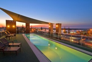 Una piscina al aire libre, sillones reclinables de piscina