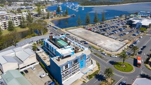 Un hotel frente al mar con estacionamiento, piscina y vistas al océano.