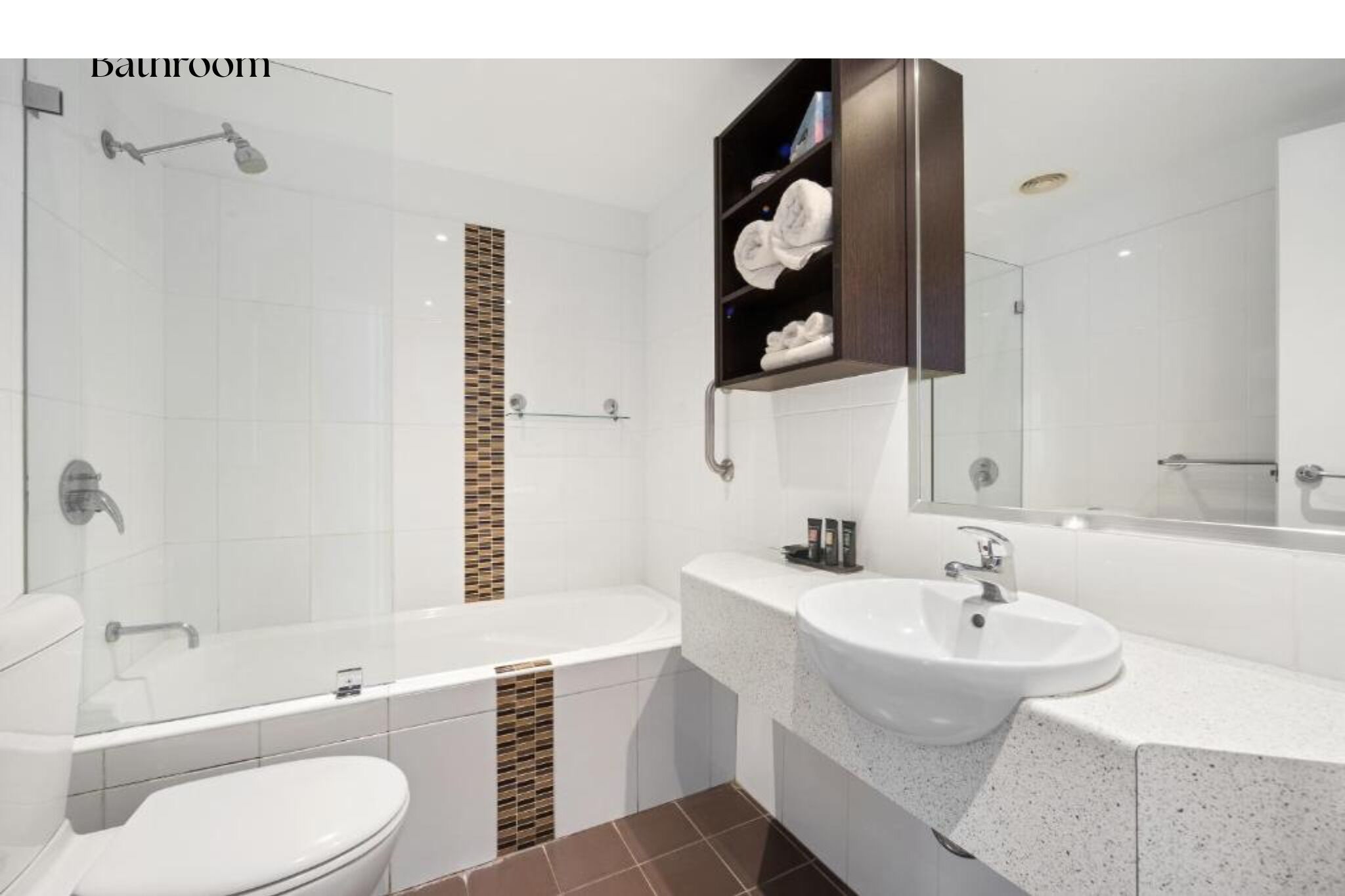Un baño moderno con ducha de vidrio, bañera, dos lavamanos y tocador con espejo.