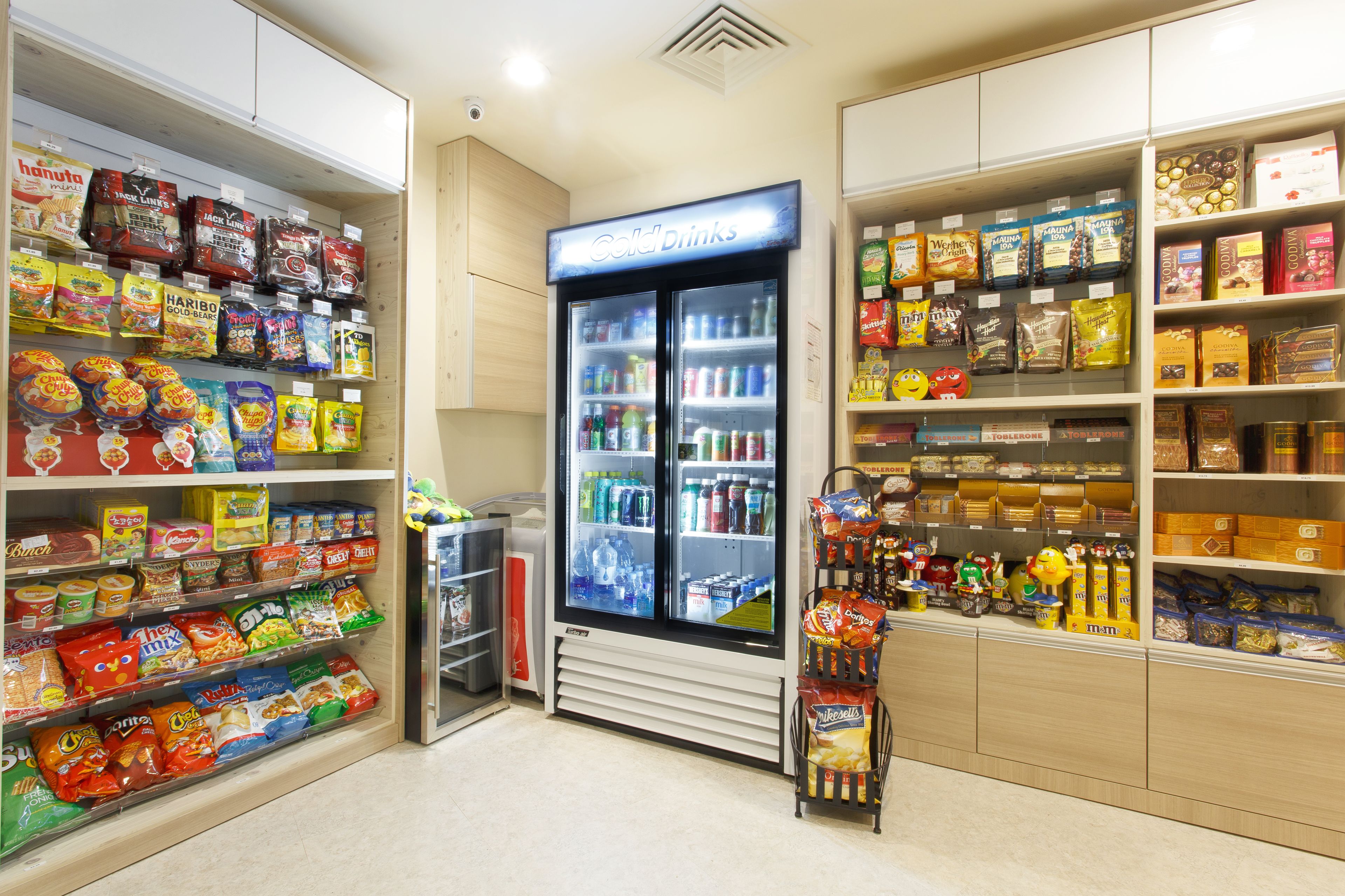 A snack and beverage section with shelves stocked with various snacks and a refrigerated display case.