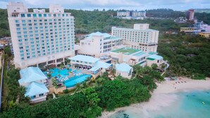 Un complexe h ôtelier comprenant plusieurs bâtiments, une piscine et une plage.