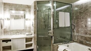 A modern bathroom with a glass-enclosed shower, a large mirror, and a bathtub.